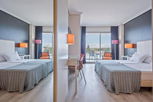 Habitación de hotel con 2 camas y escritorio en Hotel Balneario Playa de Comarruga, en Comarruga