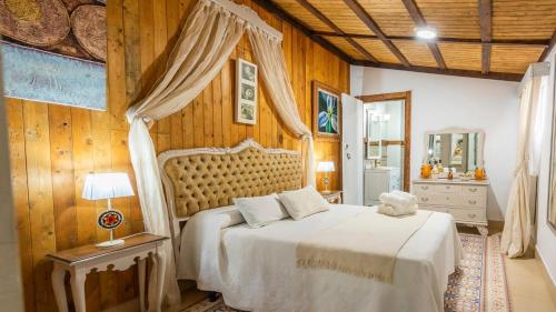 a bedroom with a bed in a room with wooden walls at Cortijo Los Mellizos Penaflor by Ruralidays in Peñaflor