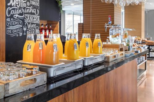 a counter with a bunch of bottles of orange juice at Hotel Madrid Chamartín, Affiliated by Meliá in Madrid