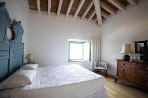 a bedroom with a bed and a dresser and a window at La Marcona in Serramazzoni
