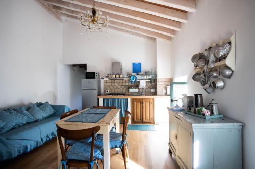 a kitchen and living room with a table and a blue couch at La Marcona in Serramazzoni