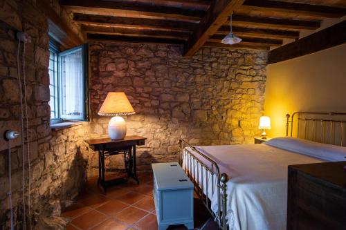ein Schlafzimmer mit einem Bett und einem Tisch mit einer Lampe in der Unterkunft La Marcona in Serramazzoni