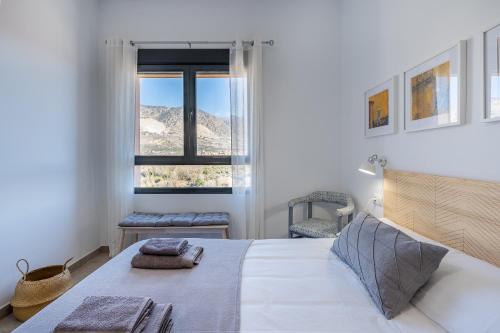 a white bedroom with a bed and a window at La Parva - Casa rural Eralta in Dúrcal