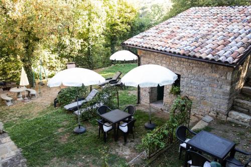 a group of tables and umbrellas in a yard at La Marcona in Serramazzoni