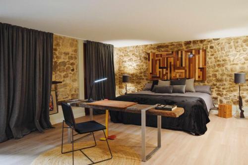 una camera con un letto e una scrivania di fronte ad essa di KelDomènech Apartment Bed Art a Besalú