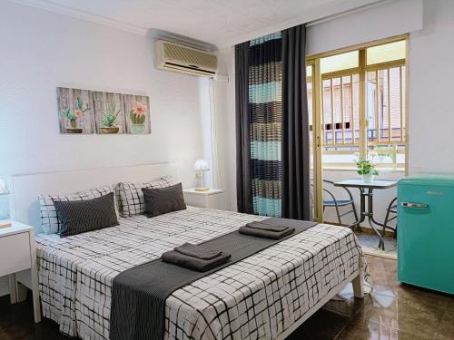 - une chambre blanche avec un lit et une table dans l'établissement Gloria Host House, à Alicante