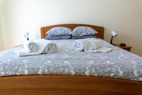 een bed met witte handdoeken en kussens erop bij Apartamento Karibu in Carvoeiro