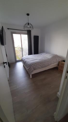 a bedroom with a bed and a large window at L'appartement de jeanne in Quimper