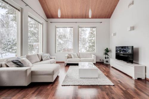 uma sala de estar com um sofá e uma televisão em Grand Villa Kivistö near Helsinki airport em Vantaa