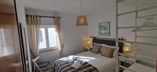a small bedroom with a bed and a window at Casa Alzira By ALzira in Albufeira
