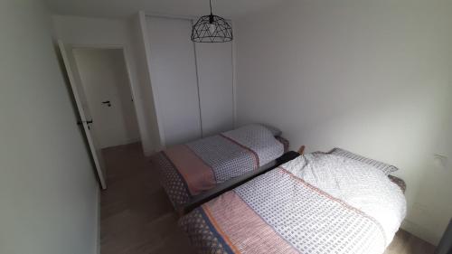 Dormitorio pequeño con cama y lámpara colgante en L'appartement de jeanne, en Quimper