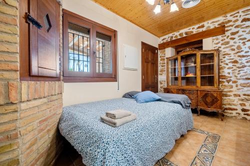 a bedroom with a bed and a brick wall at Mas del Vedell in L'Ampolla