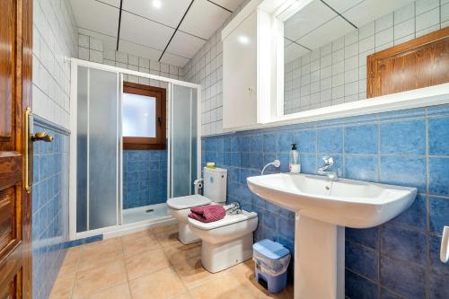 ランポーヤにあるMas del Vedellの青いタイル張りのバスルーム(洗面台、トイレ付)