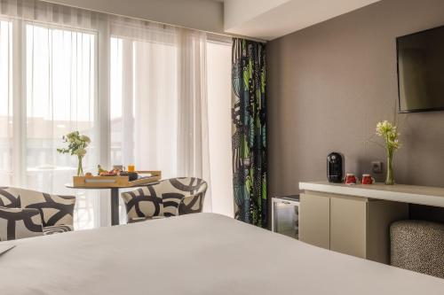a hotel room with a bed and a table with chairs at Hôtel Serge Blanco - Relais Thalasso & Spa in Hendaye