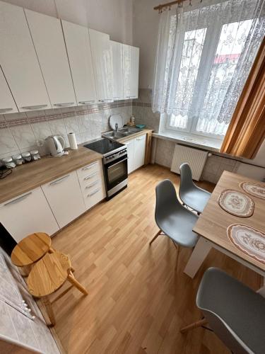 a kitchen with white cabinets and a table and chairs at Al-Dom Apartamenty Dworcowa 9 in Kołobrzeg