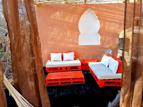 two beds in a gazebo on a porch at Riad Tazawa in Ibrahene