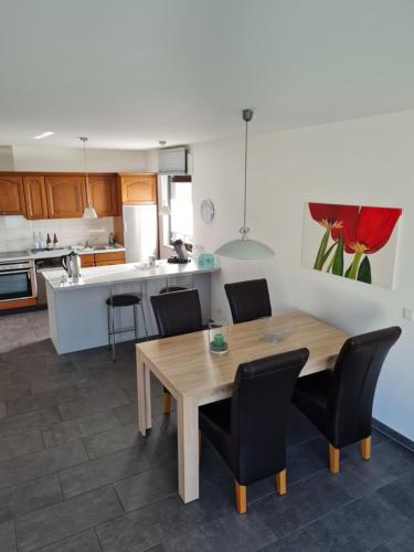 a kitchen with a wooden table and black chairs at ElHa's FeWo in Gladbeck