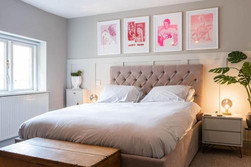 a bedroom with a large white bed with posters on the wall at Church House Loft in Scarborough