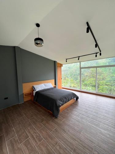 een slaapkamer met een bed en een groot raam bij Seiba Lodge 