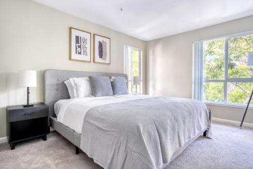 a white bedroom with a large bed and two windows at Sunnyvale 1BR w Gym WD Lounge nr Google SFO-839 in Sunnyvale