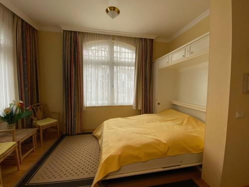 a bedroom with a yellow bed and a window at Villa Sirene Whg 4 Königsstuhl - 5 Sterne in Binz