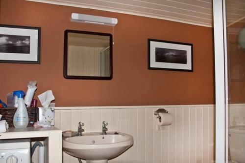 a bathroom with a sink and a mirror at The Ruah - Clifftop Retreat in Whitehall