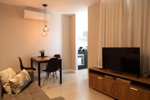uma sala de estar com uma televisão de ecrã plano e uma mesa em Art Inn Porto no Rio de Janeiro