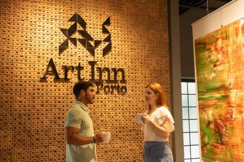 a man and a woman standing in front of a wall at Art Inn Porto in Rio de Janeiro