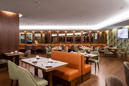 a restaurant with tables and chairs and a television at TURIM Oporto Hotel in Porto