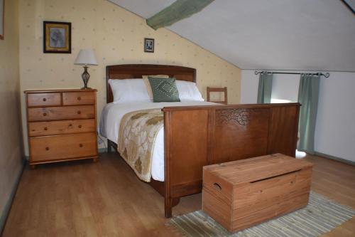 a bedroom with a bed and a wooden dresser and a bed sidx sidx sidx at L'Occitania Chambre d'hotes in Puivert