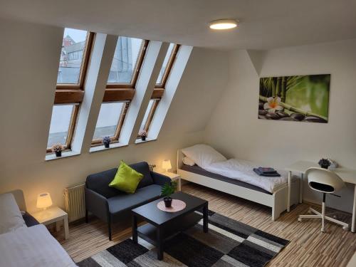 ein Wohnzimmer mit einem Sofa, einem Bett und Fenstern in der Unterkunft CityApartment Platinum-Zentrum mit Parkplatz in Bielefeld