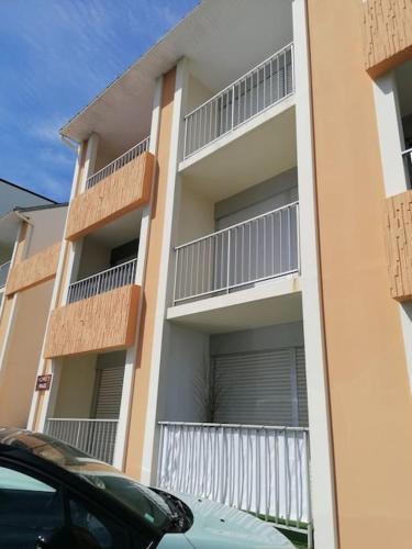 une voiture garée devant un immeuble avec balcon dans l'établissement Studio Quiberon au Calme à 200 m de L embarcadère, à Quiberon