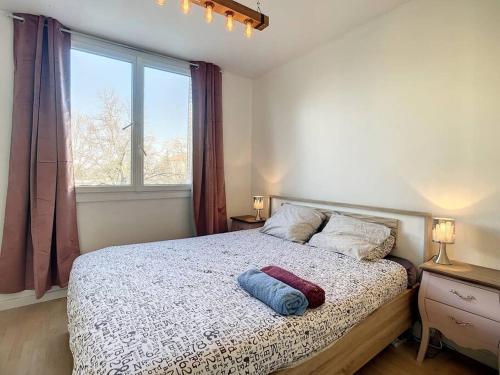 Un dormitorio con una cama con dos almohadas y una ventana. en Shining Sun Flat Lyon Caluire et parkings, en Caluire-et-Cuire