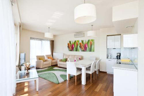 a kitchen and living room with a table and chairs at Apartamenty Sun & Snow Ciągłówka in Zakopane