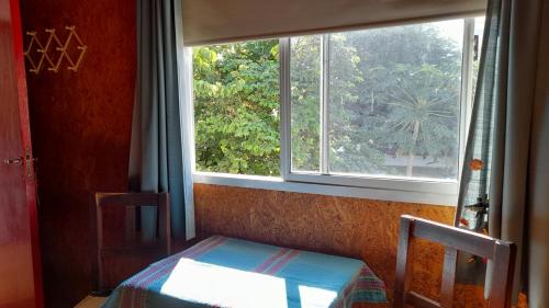 a room with a window and a bed and a table at Campanita amarilla in Salta