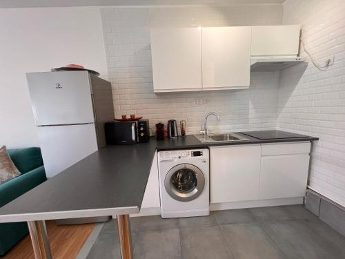 Il comprend une cuisine équipée d'un réfrigérateur blanc et d'un lave-linge. dans l'établissement Studio Champs-Elysées - HALA PARIS, à Paris