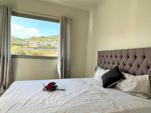 a bed with a flower on it with a window at Yamina Rooftop Residence in Agia Pelagia