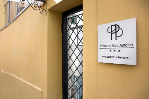 a sign on the side of a building with a window at Palazzo Sant'Antonio in Naples