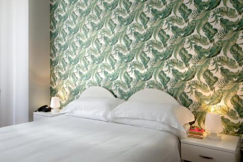a bedroom with a white bed with a green and white wallpaper at Palazzo Sant'Antonio in Naples