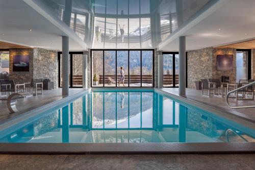 - une grande piscine dans un bâtiment doté de fenêtres dans l'établissement Les Granges d'en Haut - Chamonix Les Houches, aux Houches