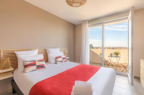 - une chambre avec un grand lit et un balcon dans l'établissement Appart'City Confort Toulouse Aéroport Cornebarrieu, à Cornebarrieu