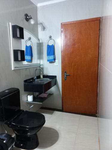 uma casa de banho com um WC preto e um lavatório. em Salto dos hermanas em Puerto Iguazú