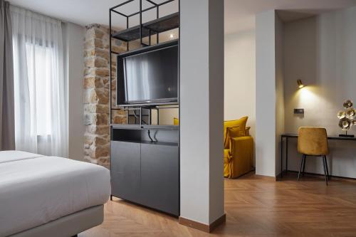 sypialnia z łóżkiem i telewizorem z płaskim ekranem w obiekcie HOTEL ARRIZUL CATEDRAL w mieście San Sebastián