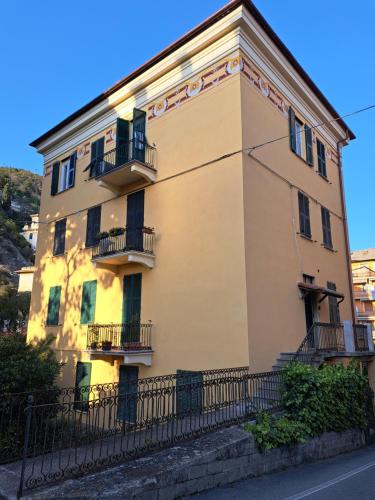 un bâtiment jaune avec balcon et clôture dans l'établissement Preia de ma, à Levanto