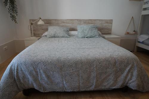 een slaapkamer met een bed met een dekbed erop bij A Casa do Choco in Redondela