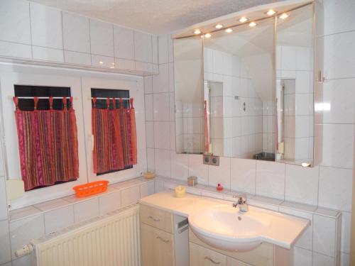 ein Bad mit einem Waschbecken und einem Spiegel in der Unterkunft Haus Gisela in Endingen