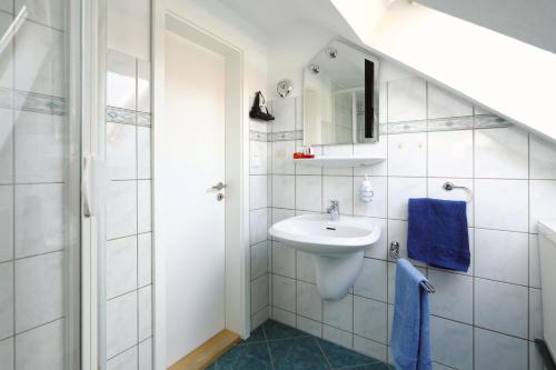 Baño blanco con lavabo y espejo en Ferienwohnung Damerow en Zinnowitz