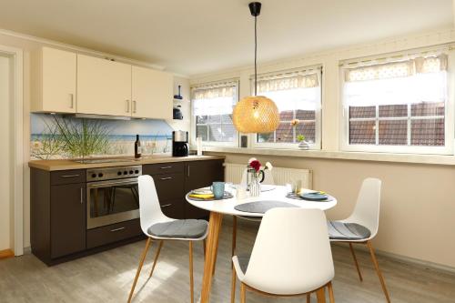 a kitchen with a table and white chairs in it at Ferienwohnung Damerow in Zinnowitz