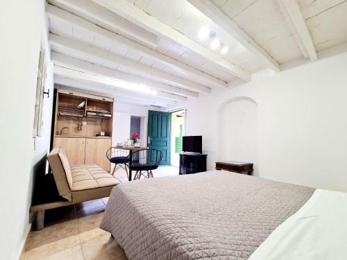 una camera con letto, sedia e tavolo di Piccolo Modern Suites Old Town a Città di Rodi