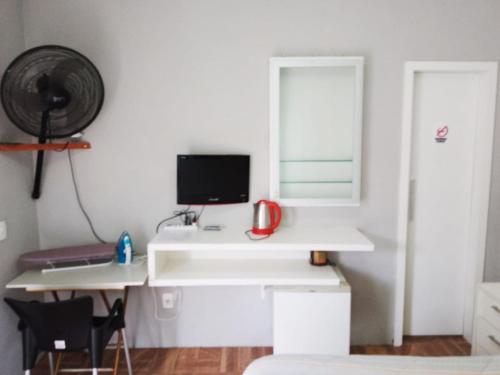 a room with a white desk with a computer on it at Espaço aconchegante Blumenau in Blumenau